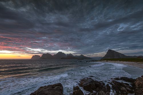 Free Stunning sunset view of the rugged Lofoten coastline with dramatic clouds and rocky beach Stock Photo