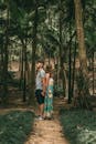 一对夫妇手牵着手，在绿树成荫的宁静森林中漫步