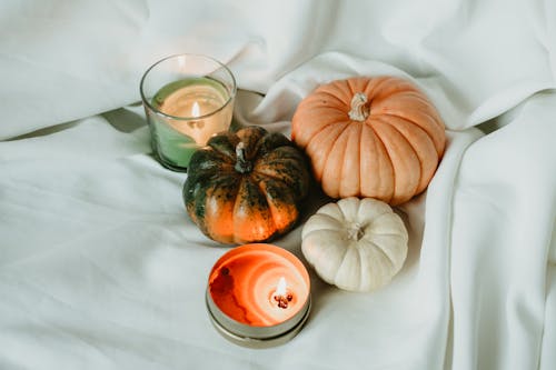 Candles and Pumpkins on a White Sheet