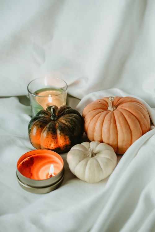 Free A warm autumn setting with pumpkins and candles for a festive mood. Stock Photo
