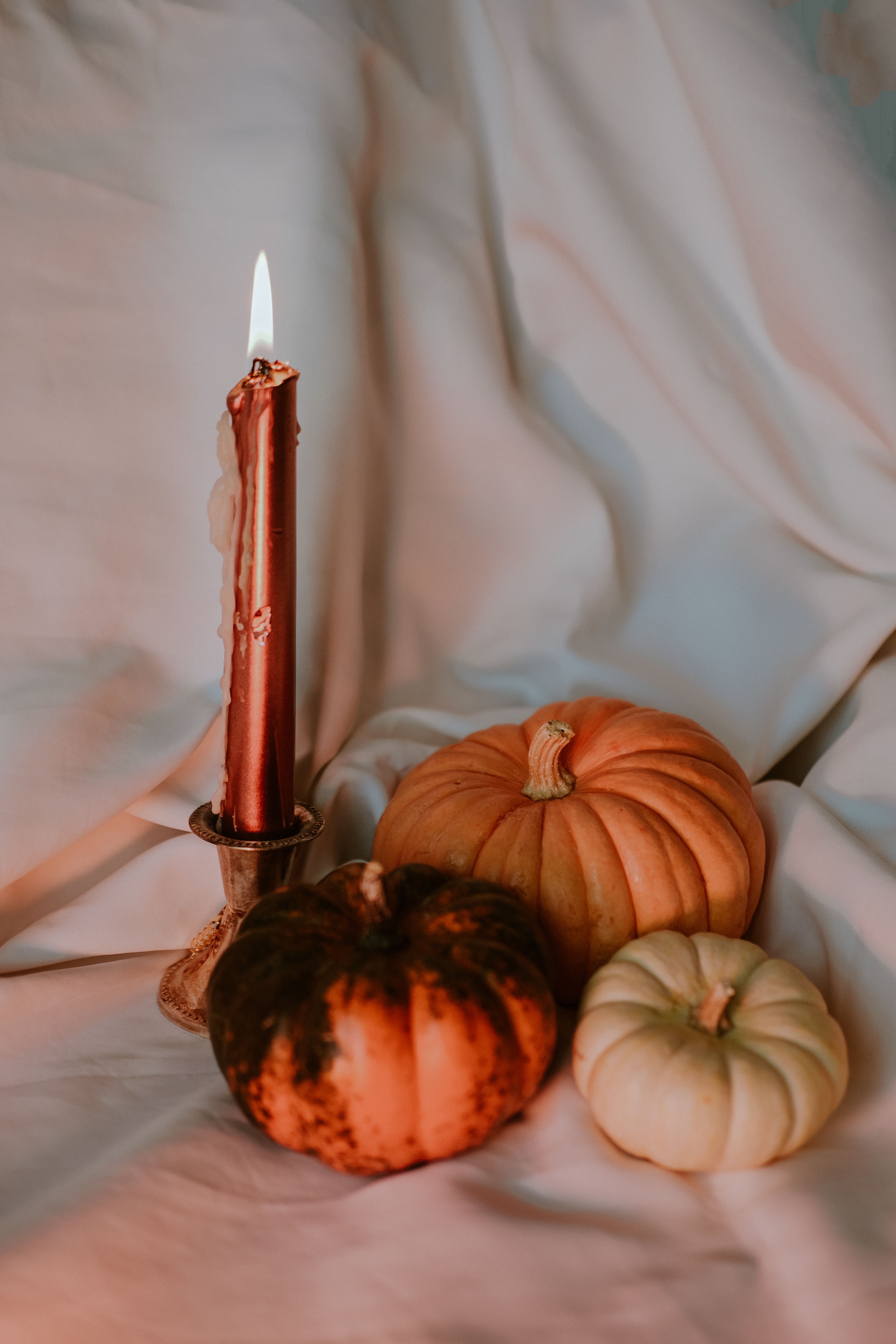 Warm autumn scene of pumpkins and a candle, perfect for seasonal celebrations.