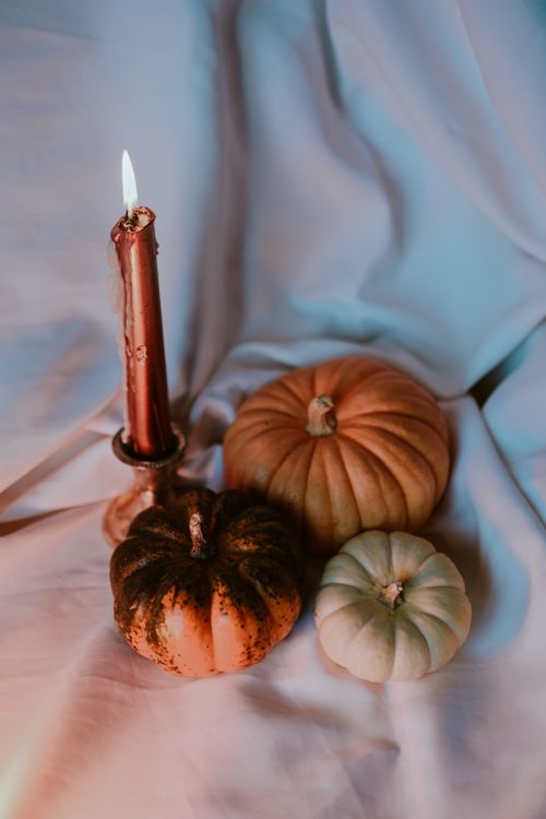Free Warm autumn scene featuring pumpkins and a candle, perfect for fall celebrations and decor inspiration. Stock Photo