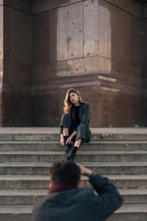 Photographer Photographing a Female Model Sitting on Outdoor Steps