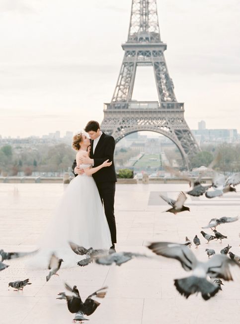 Elegant wedding portrait of couple kissing near Eiffel Tower, Paris.