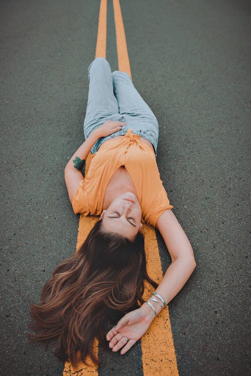 Free Woman Lying On The Road Stock Photo