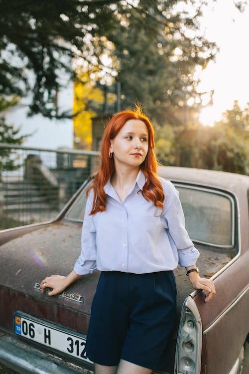 Model in a Purple Blouse and Navy Blue Mini Skirt Leaning on Old Abandoned Car