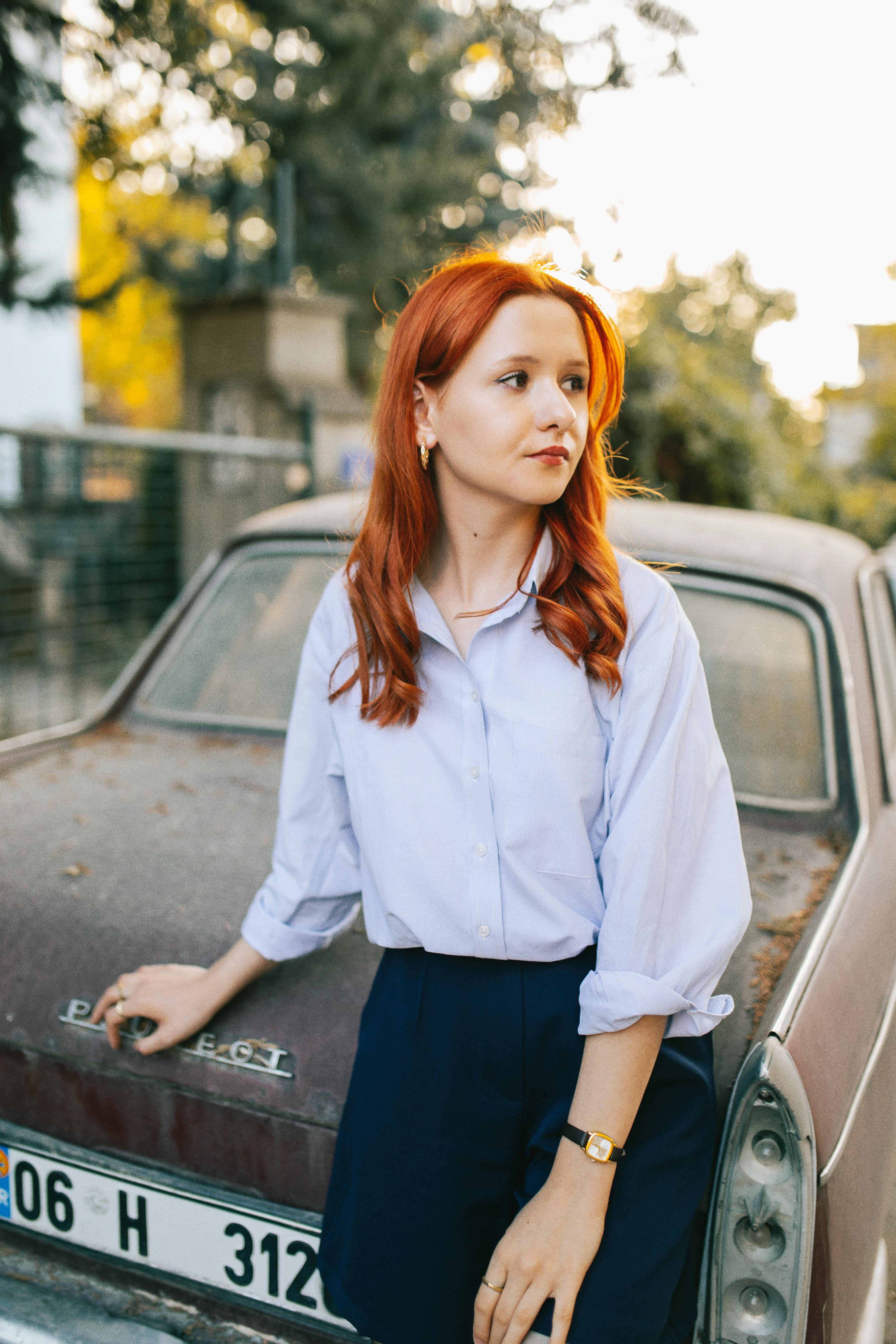 Pretty Redhead Leaning on a Car · Free Stock Photo