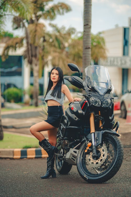 Brunette Woman in Gray Crop Top and Black Mini Skirt Posing by a Motorcycle