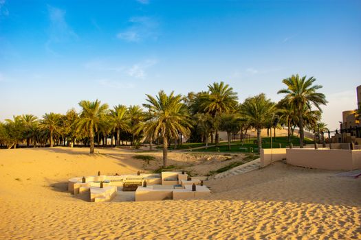 A serene tropical resort with lush palm trees and golden sands under a clear blue sky, perfect for a summer escape.