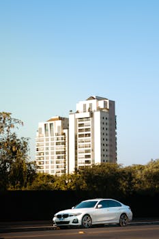 White sports car on street against high-rise buildings in Anápolis, GO, Brasil.