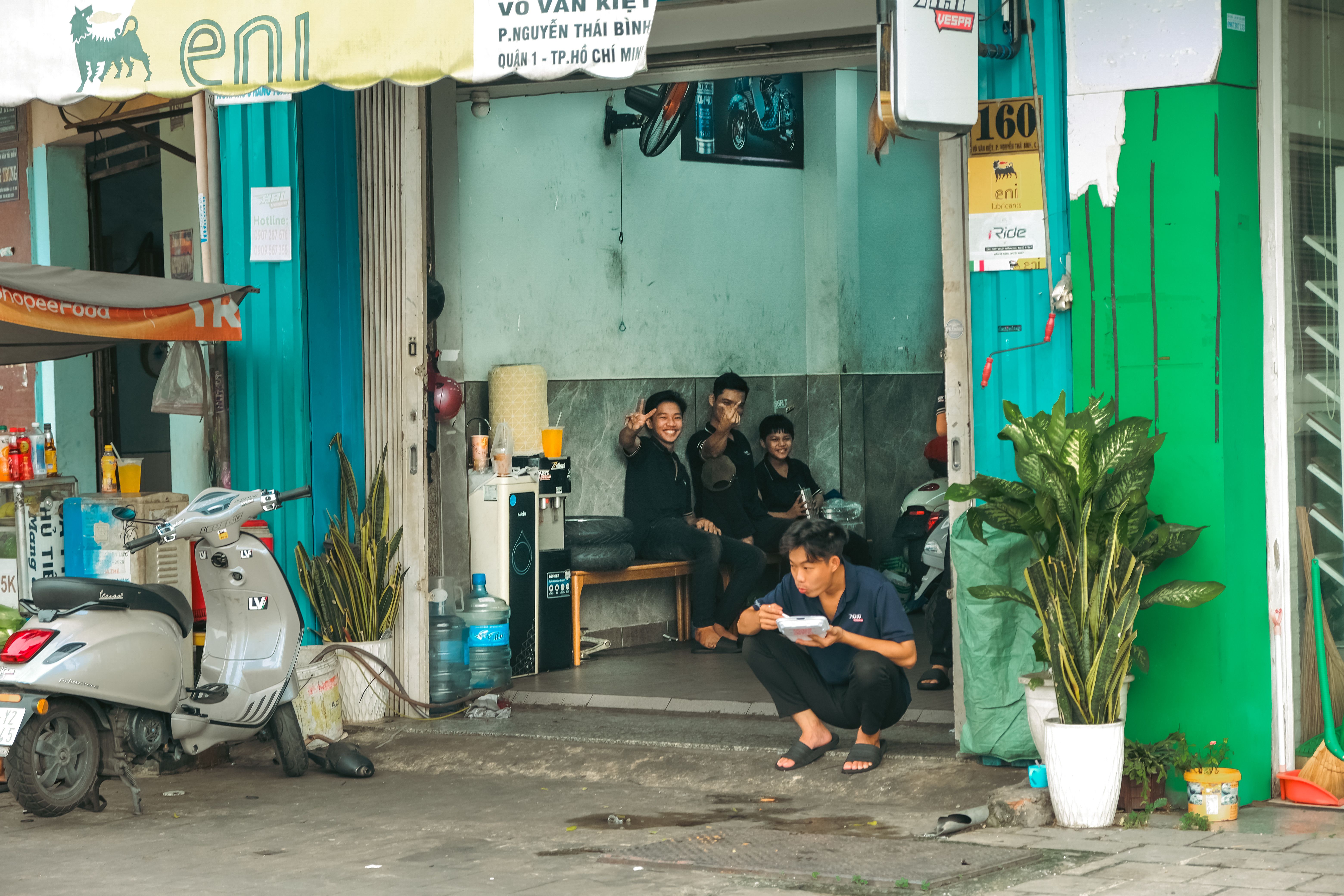 A traveler shaking hands with a Community Watch volunteer in front of a local shop in Ho
