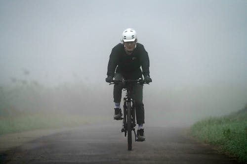 Man Riding on a Bike in Fog