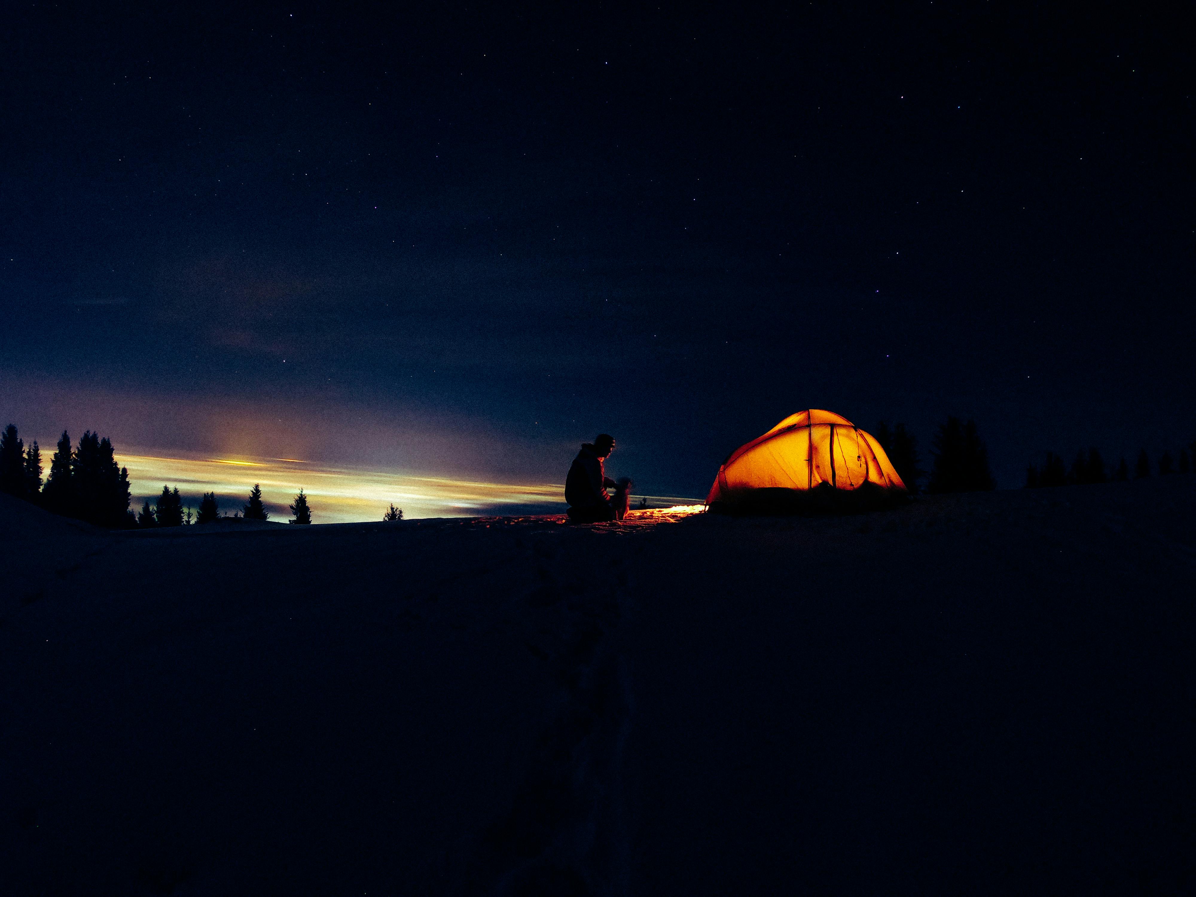 silhouette of man in front of tent