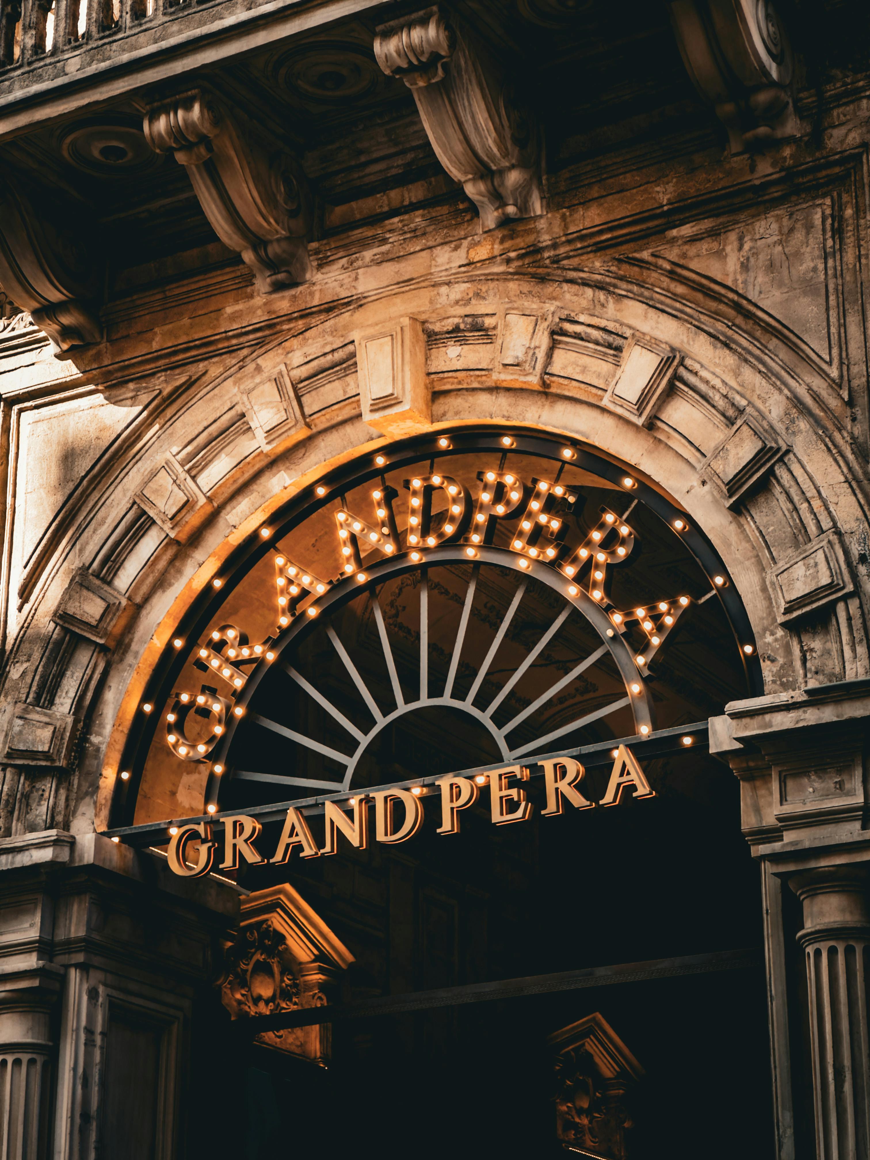Illuminated entrance of Grand Pera, a historical landmark in Istanbul, Turkey.