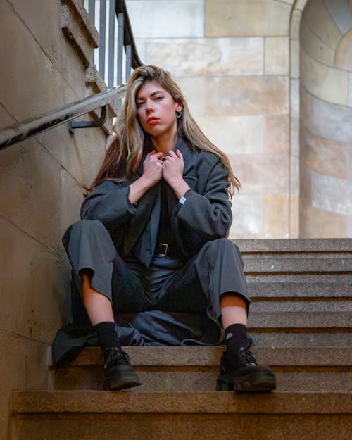 Blonde Woman in Gray Suit Sitting on Stairs