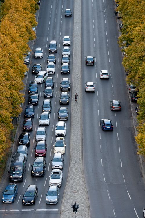 Free Aerial shot of heavy traffic on a city highway lined with autumn trees. Stock Photo