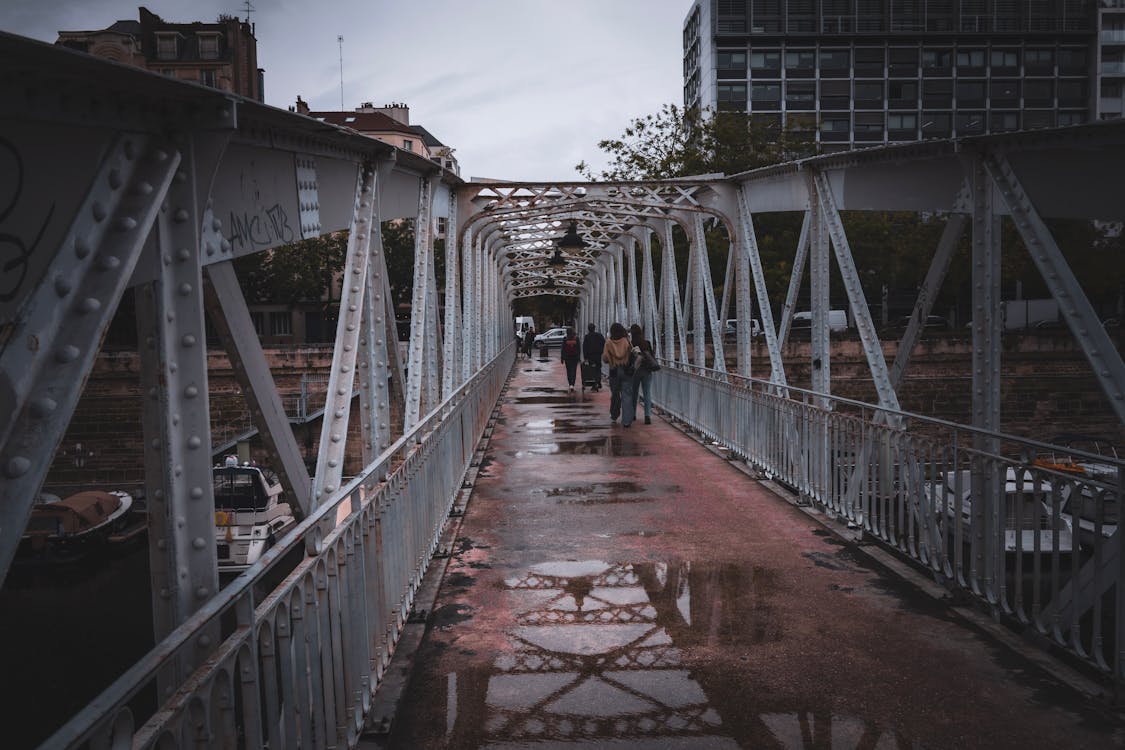 People Walking on Metal Pedestrian Bridge after Rain · Free Stock Photo