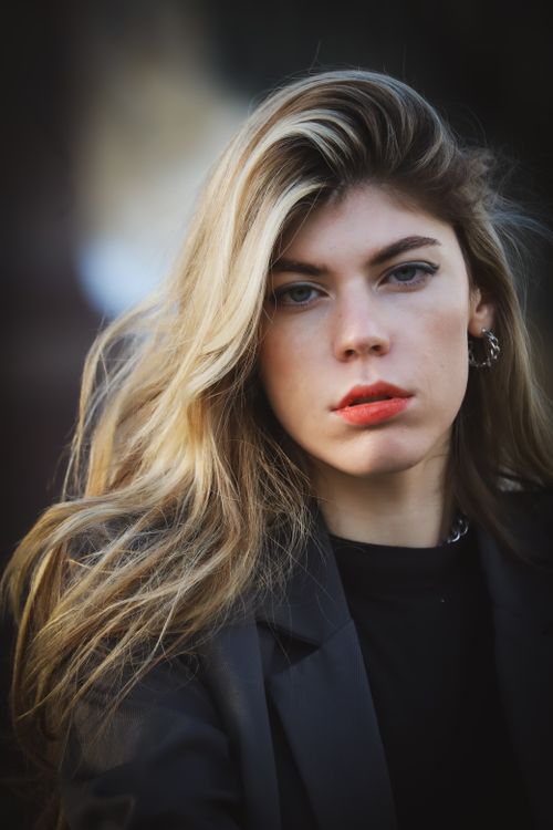 Free Close-up portrait of a young woman in a black blazer with long blonde hair. Stock Photo