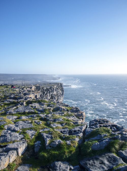 Free Sunlit cliffs of Inishmore, Ireland with a breathtaking view of the Atlantic Ocean. Stock Photo