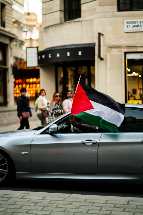 Man in Car Holding Palestine Flag
