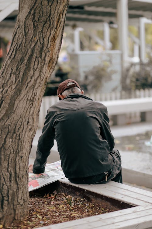 Elderly Man Reading Newspaper on a Street