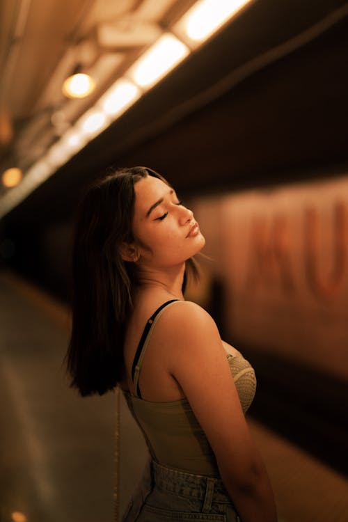 Young Woman Standing on a Subway Platform 