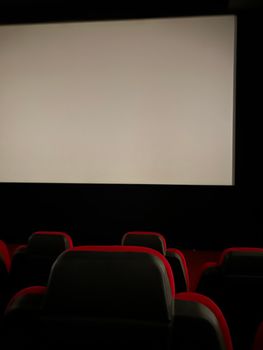 Explore an empty cinema hall in Çanakkale, Türkiye with red seats and a large screen.
