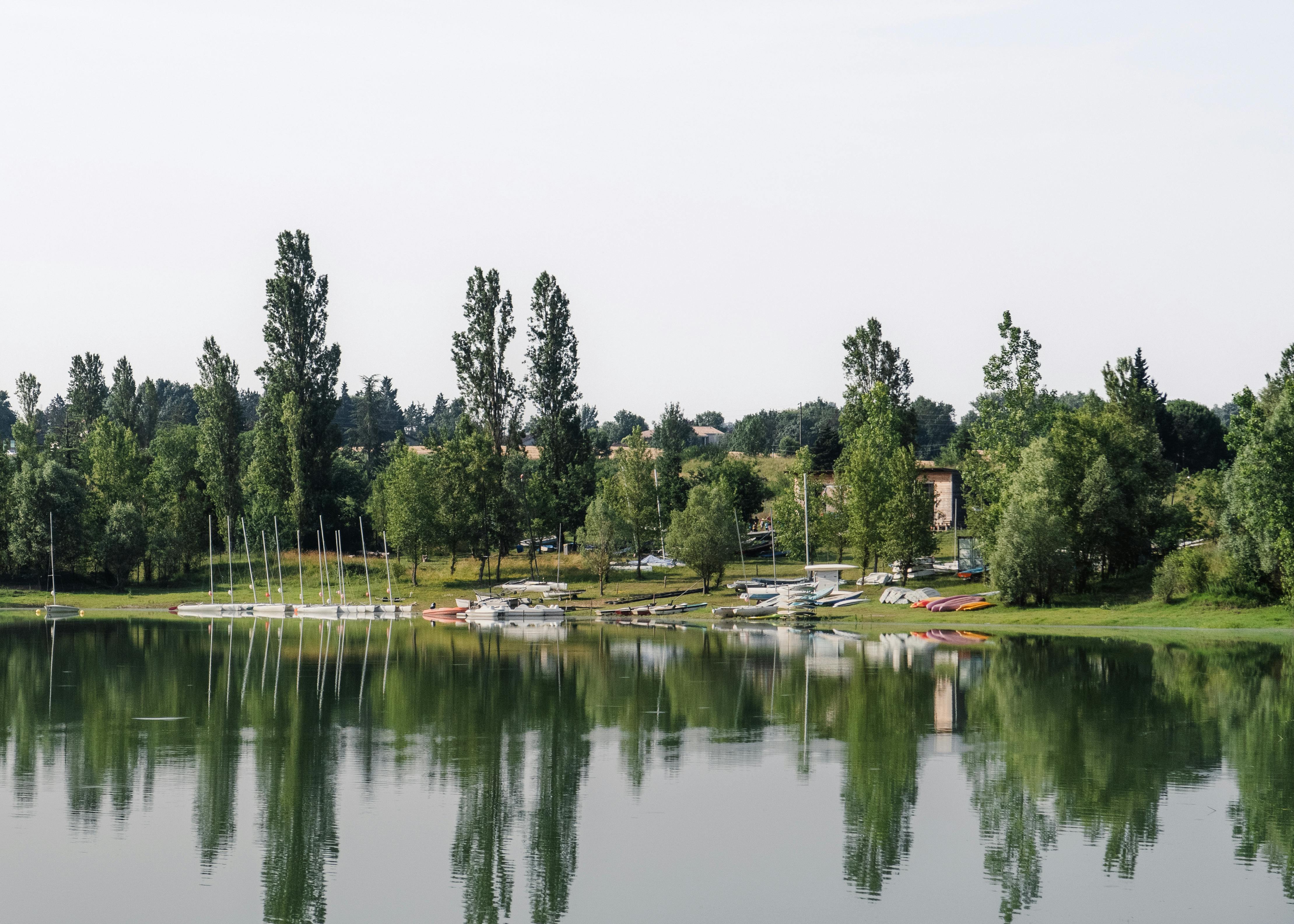 Tranquil view of a lake with kayaks in Thoux, Occitanie, France.