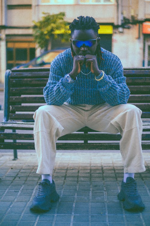 Man in Sweater Sitting on Bench