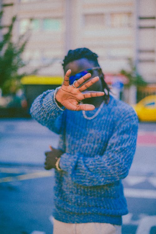 Man in Blue Sweater Posing on a Street