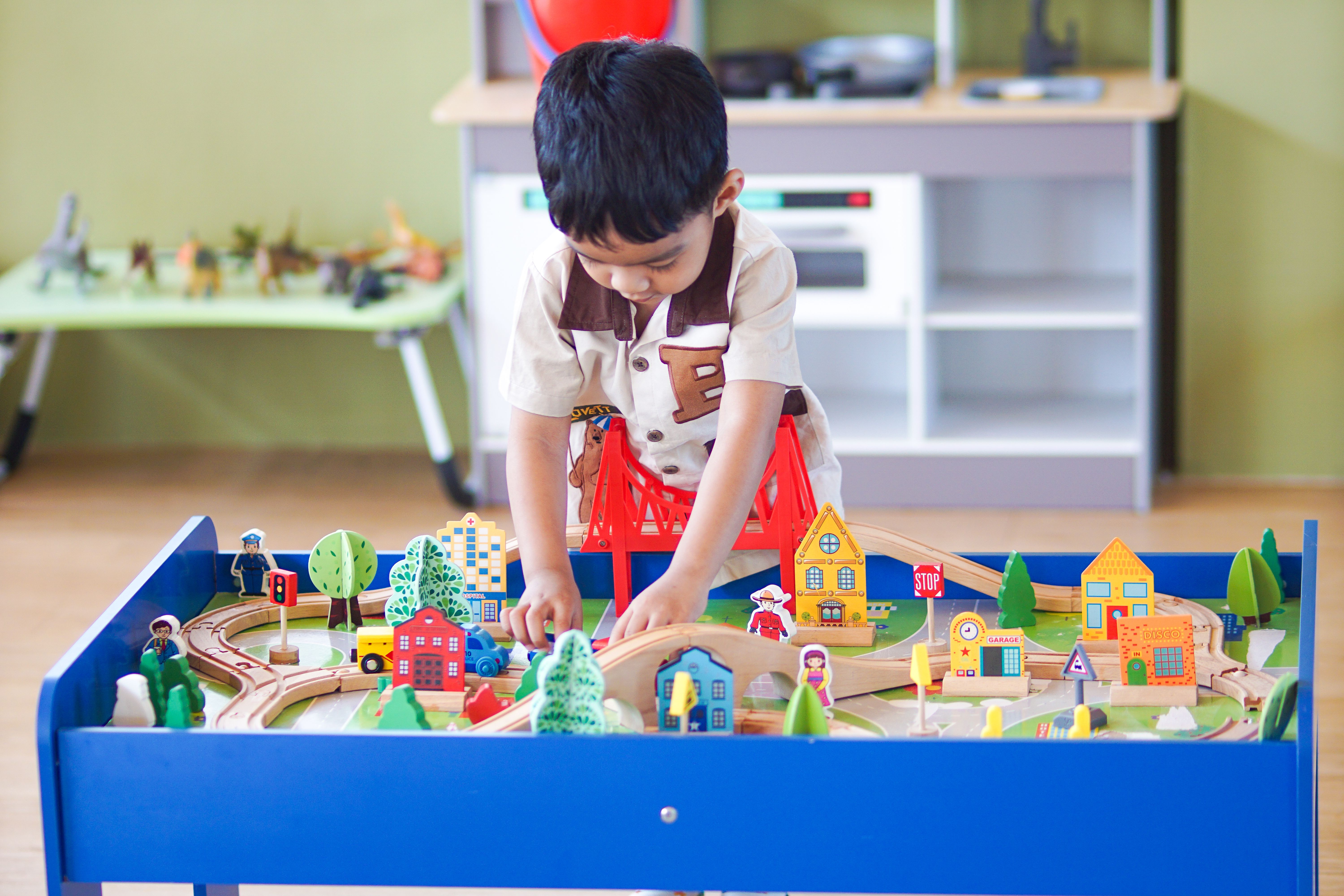 Free Young boy playing with a colorful wooden toy set, enhancing creativity and learning indoors. Stock Photo