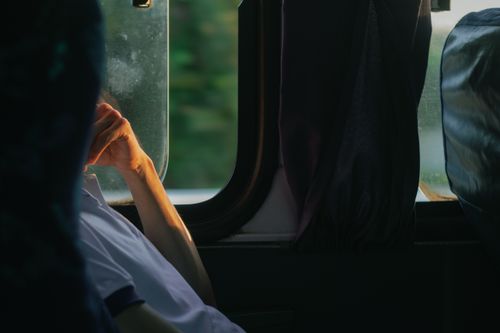 Free A man sitting pensively on a bus, gazing out the window during daytime travel in Paudalho, Brazil. Stock Photo