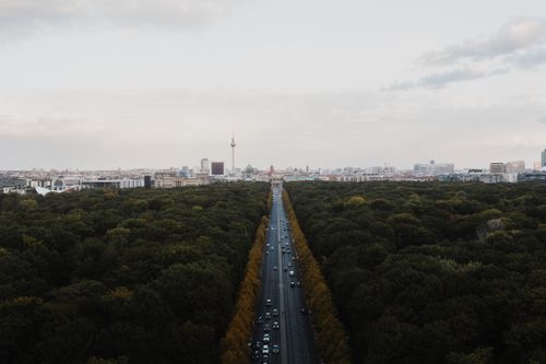 Free A drone shot of Berlin's skyline from above the forest, showcasing the TV Tower and urban landscape. Stock Photo
