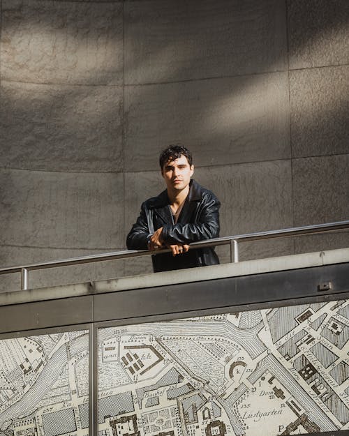 Man in Leather Jacket over Map on Wall