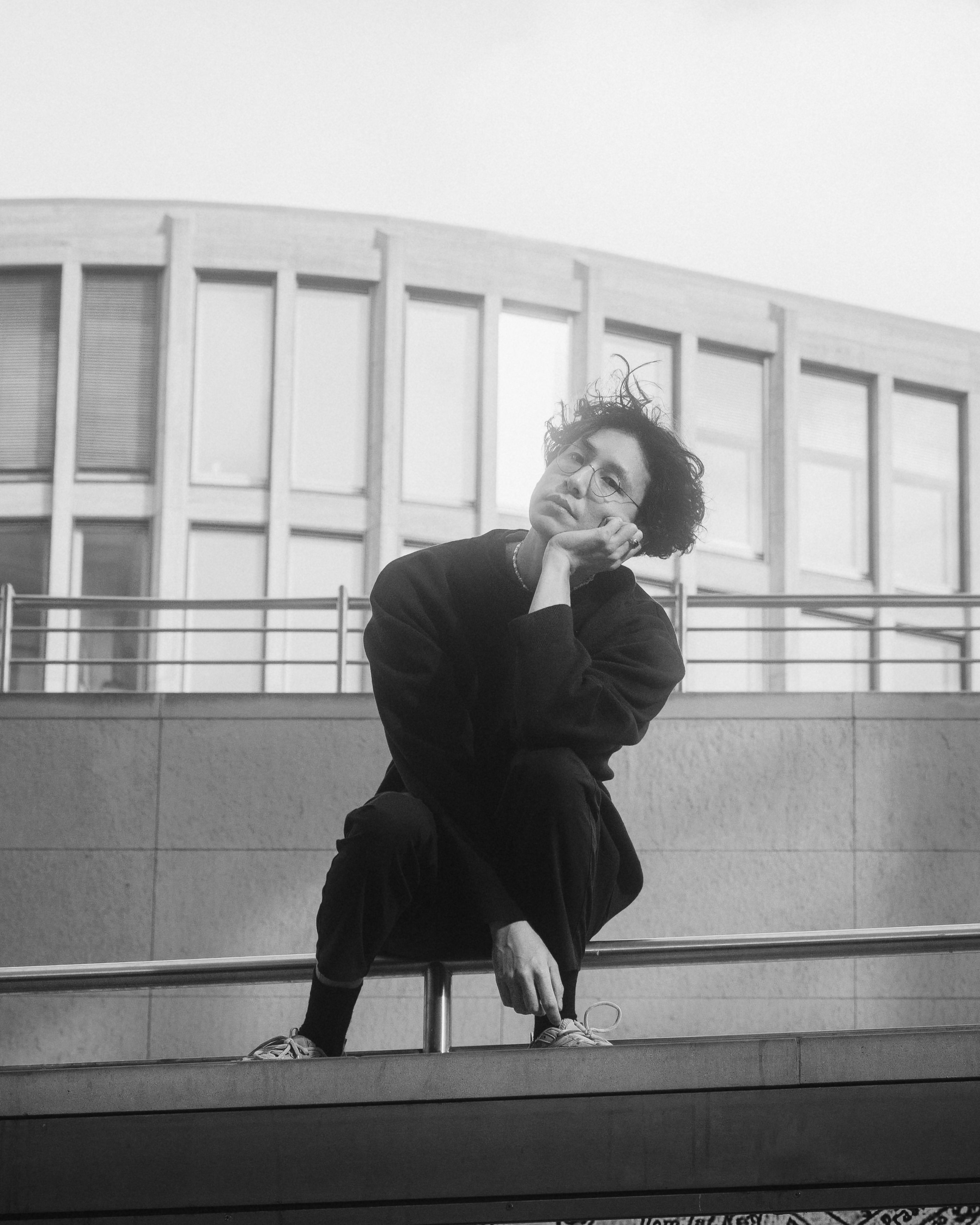 Black and White Photo of a Young Man Sitting on a Handrail · Free Stock ...