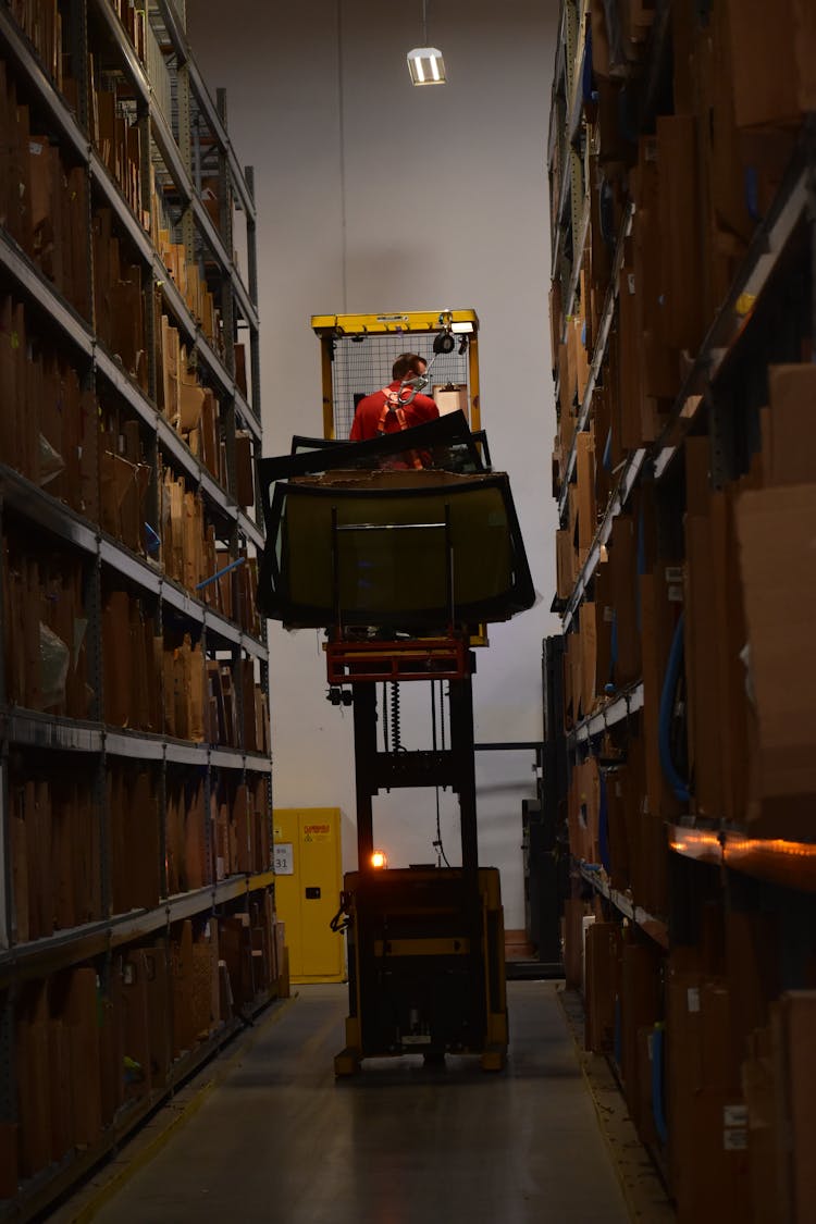 Auto Parts Warehouse Worker With Windshields On A Forklift