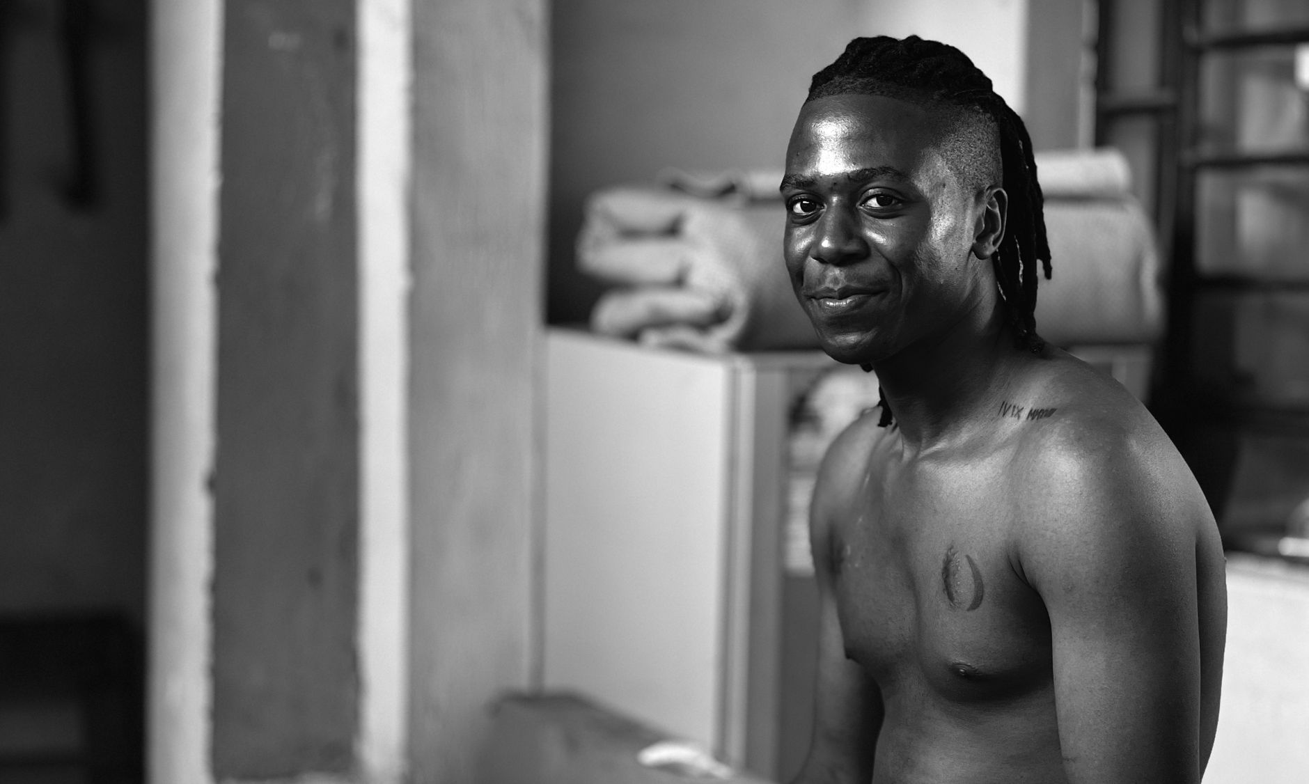 Portrait of a young man smiling, black and white documentary photograph — illustrative placeholder