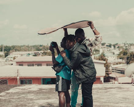 Three friends on a rooftop engaged in a photography session under sunny skies.