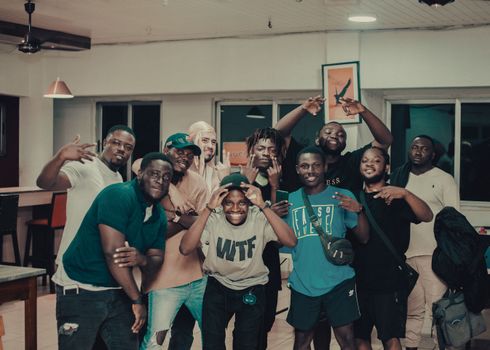 A group of smiling friends posing together indoors, radiating joy and camaraderie.
