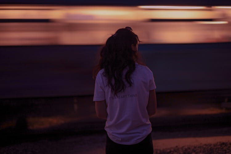 Train Passing Behind Woman In T-shirt