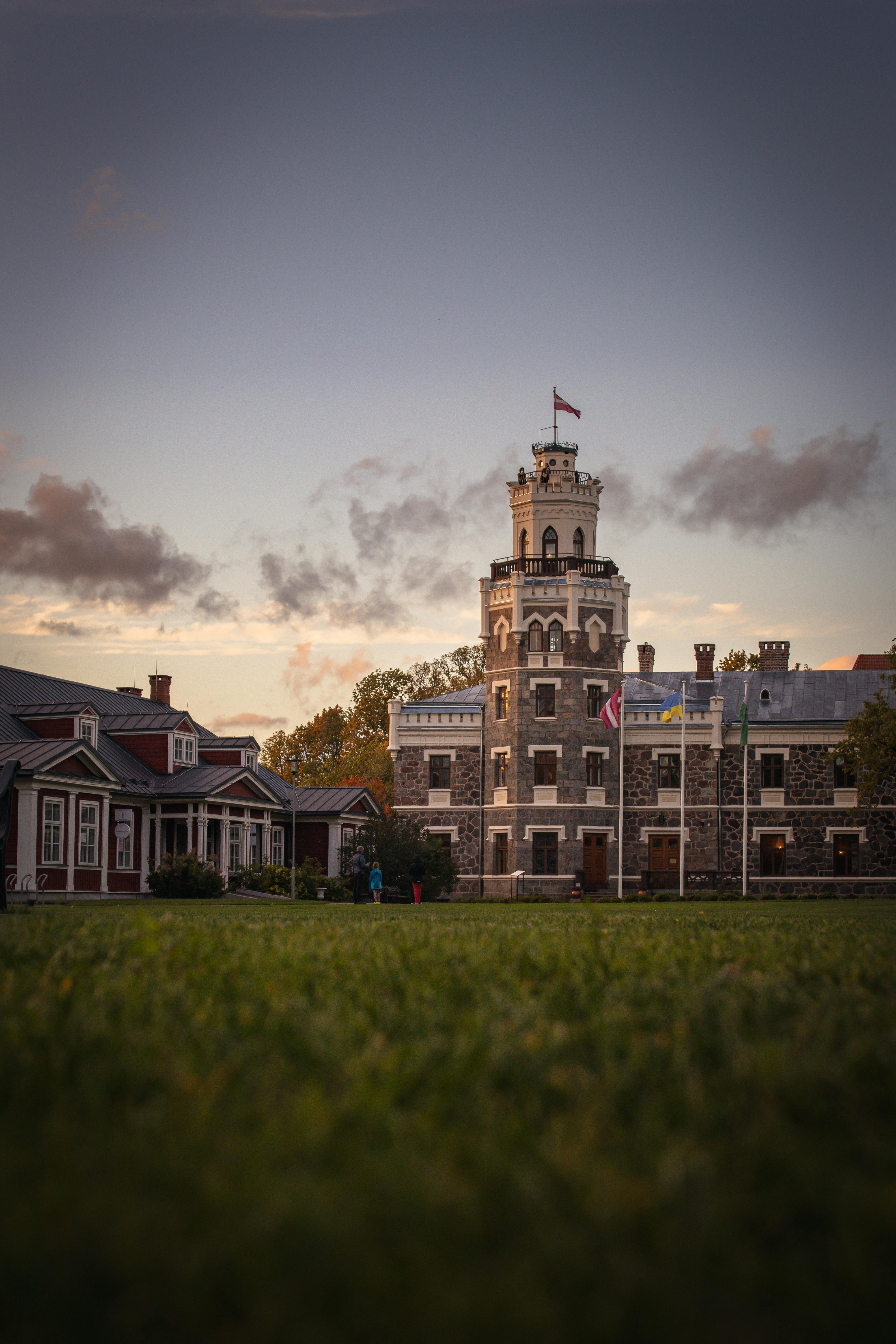 Capture of a majestic Neo-Gothic manor in Latvia with a sunset backdrop.