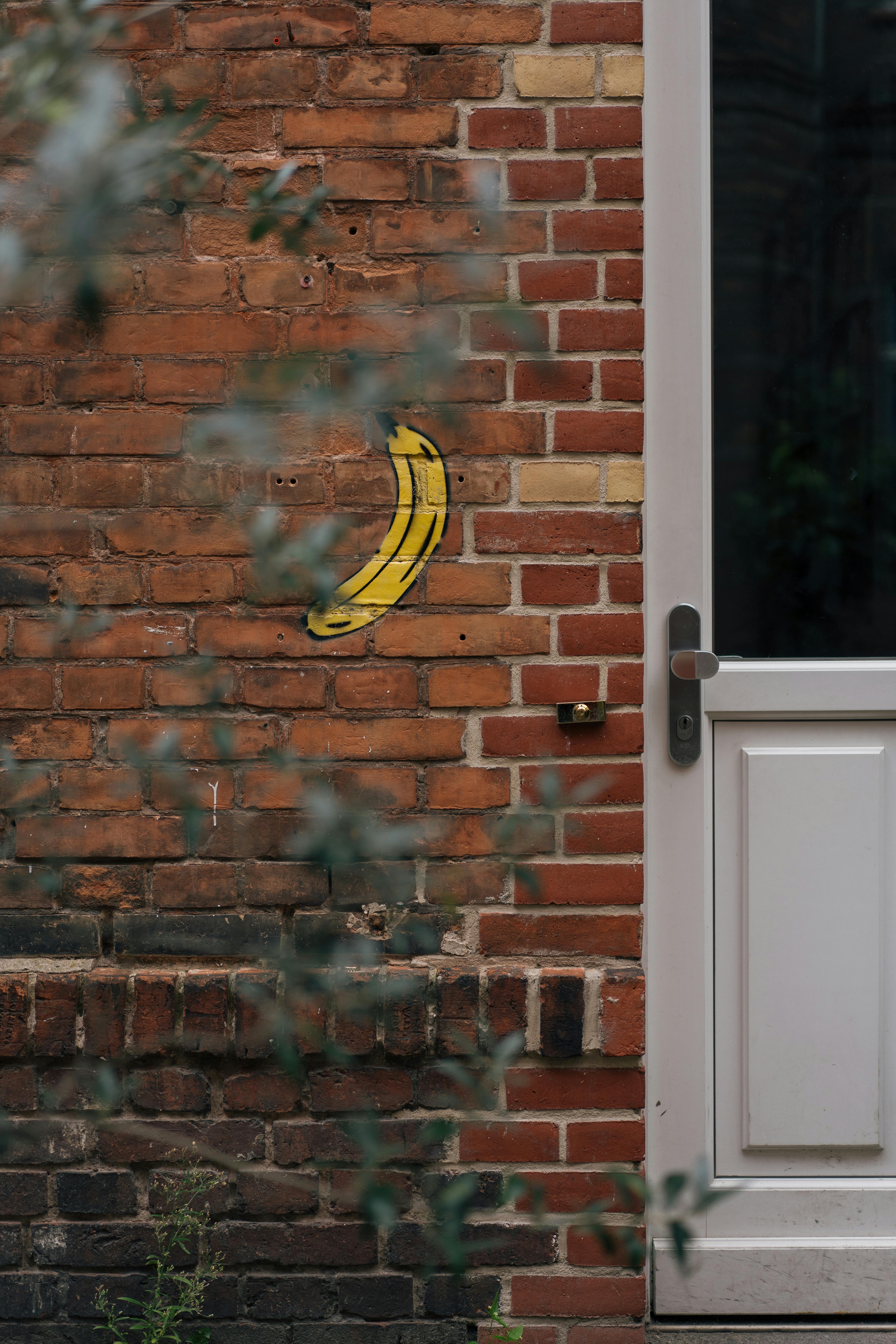 Banana on Wall Bricks · Free Stock Photo