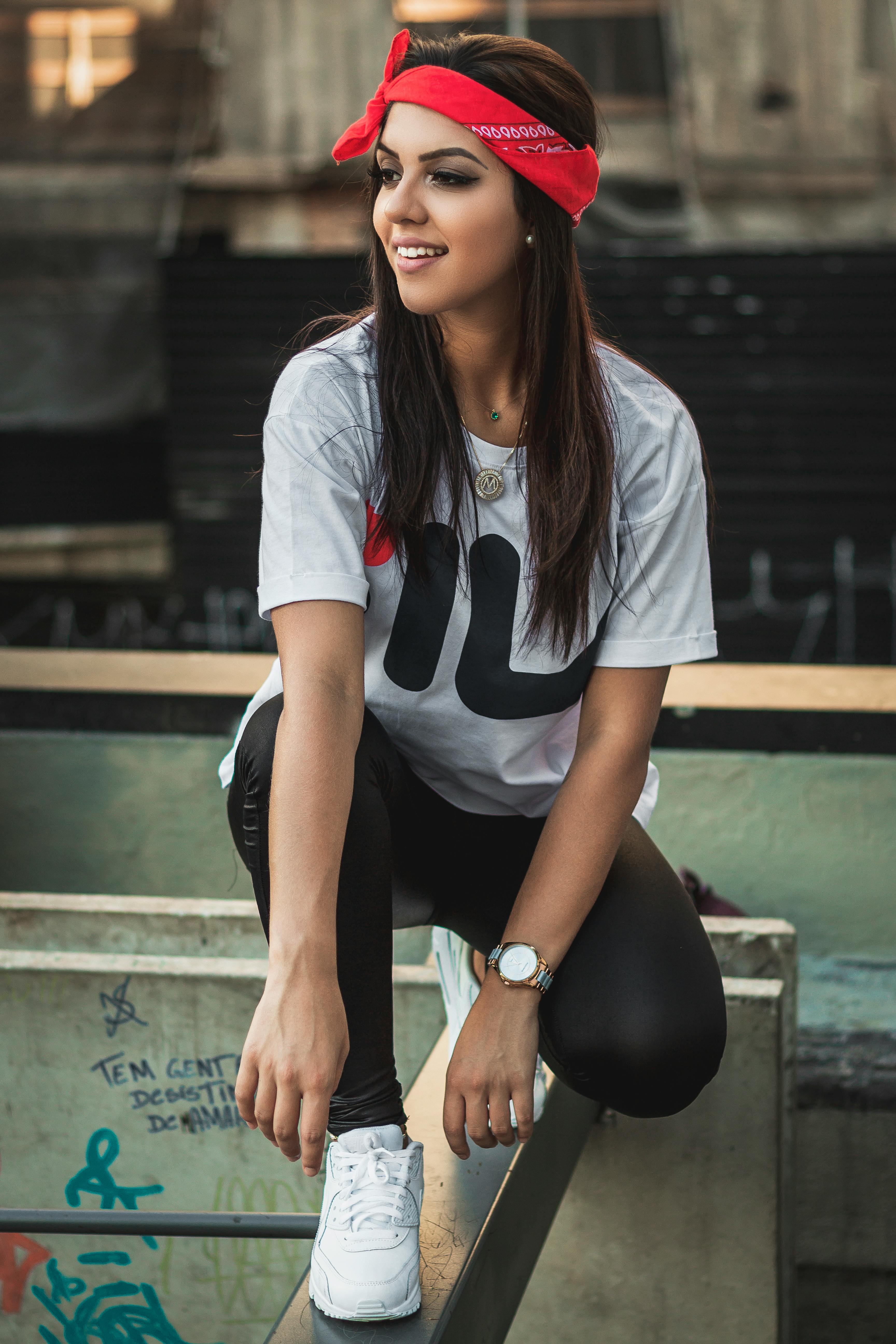 一位时尚女性穿着休闲服，在户外带着自信的微笑摆姿势