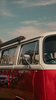 Classic red van side view outdoors under blue sky, capturing retro charm.
