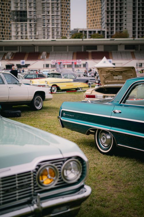 Free Classic muscle cars displayed outdoors in an urban stadium, showcasing vintage aesthetics. Stock Photo
