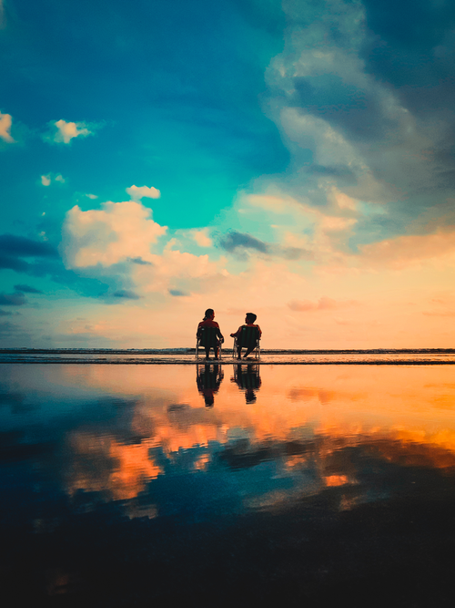 Person Wearing Hoodie Standing On Rock Surrounded By Body Of Water person-wearing-hoodie-standing-on-rock-surrounded-by-body-of-water