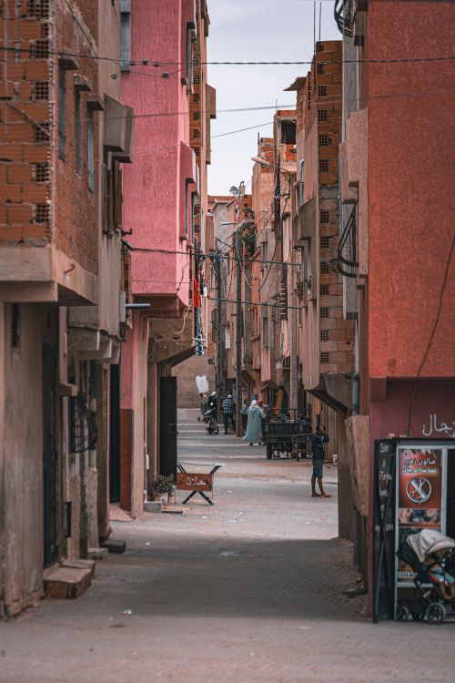 Free A bustling narrow alley with colorful buildings and people in an urban setting. Stock Photo