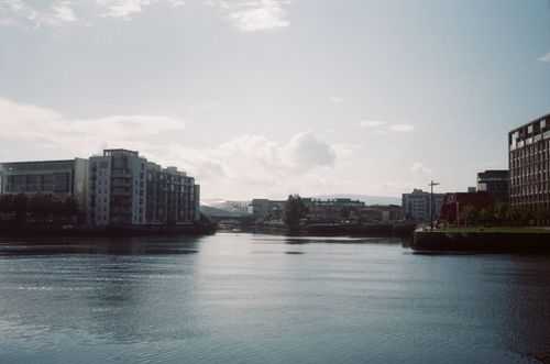 Free Cityscape view featuring modern buildings alongside a tranquil river. Stock Photo
