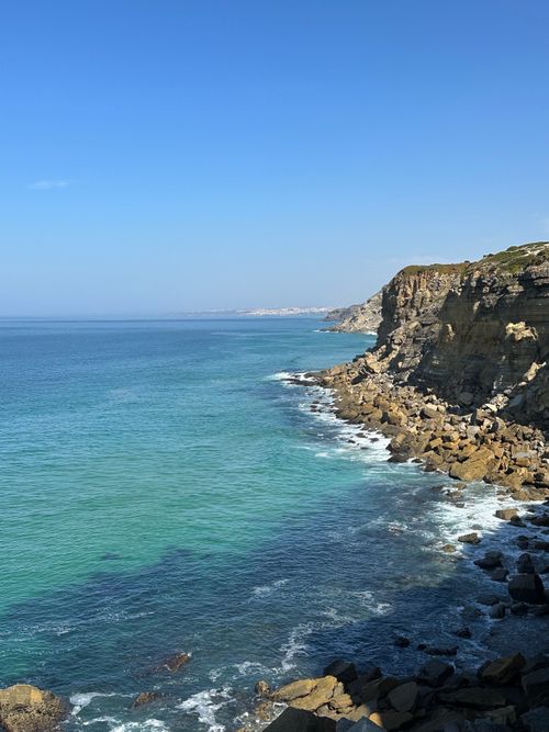 Free Breathtaking view of a towering coastal cliff and azure sea under a clear blue sky. Stock Photo