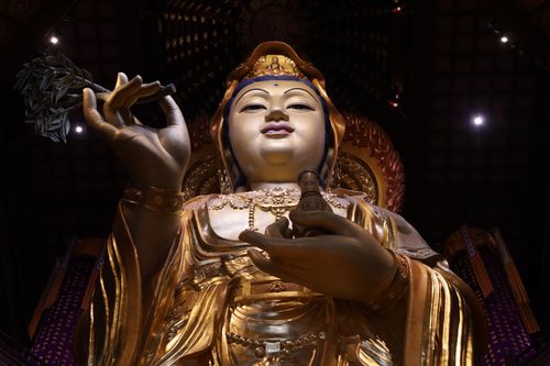 Free Majestic statue of Bodhisattva Guanyin inside a traditional Chinese temple. Stock Photo